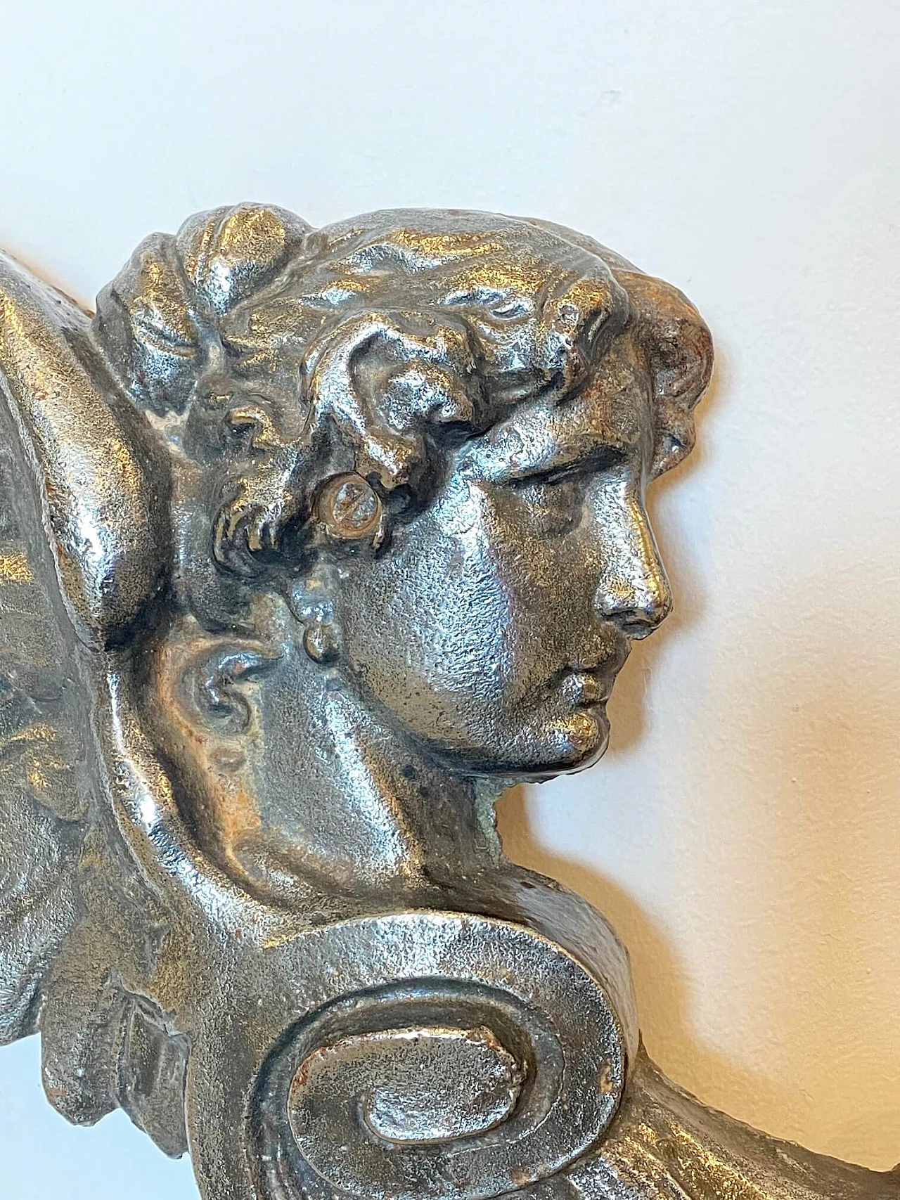 Coppia di elementi decorativi rappresentanti figure alate in ghisa, anni '10 1219095