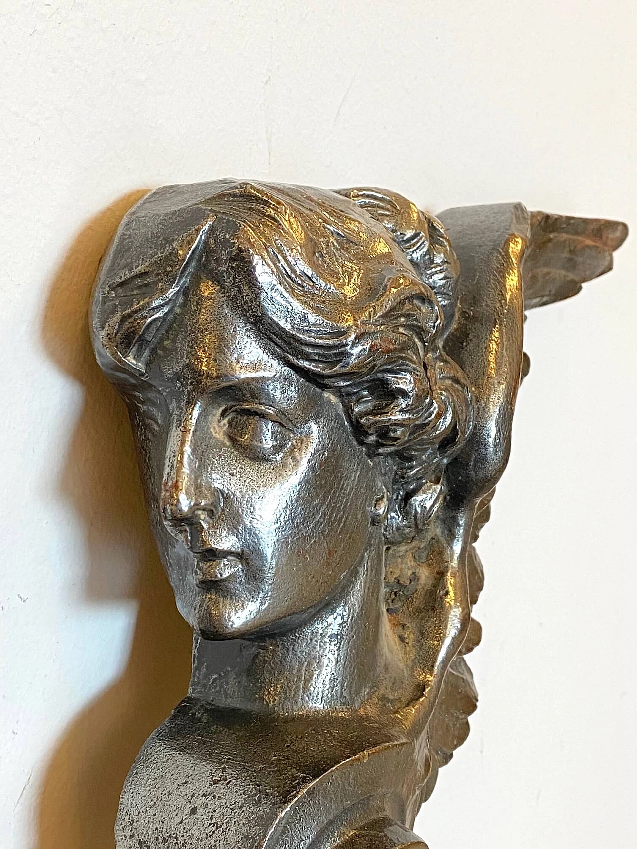 Coppia di elementi decorativi rappresentanti figure alate in ghisa, anni '10 1219099