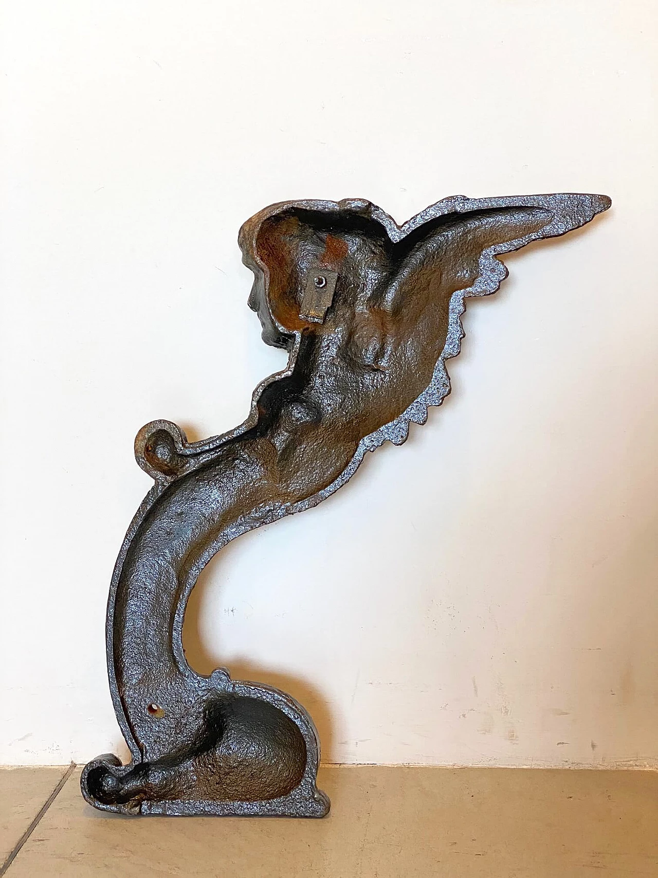 Coppia di elementi decorativi rappresentanti figure alate in ghisa, anni '10 1219100