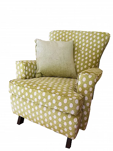 Green fabric armchair with white polka dots