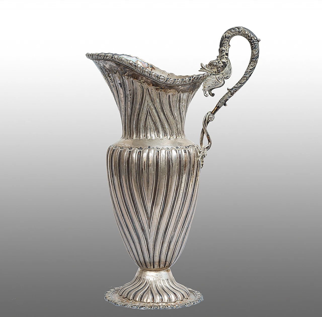 Silver sinusoidal-shaped jug with thick chisel on the edge 1