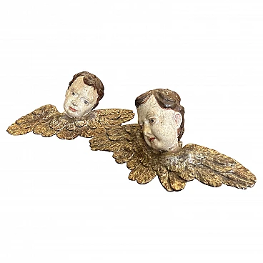 Pair of lacquered and carved wood winged angel heads, 1750s