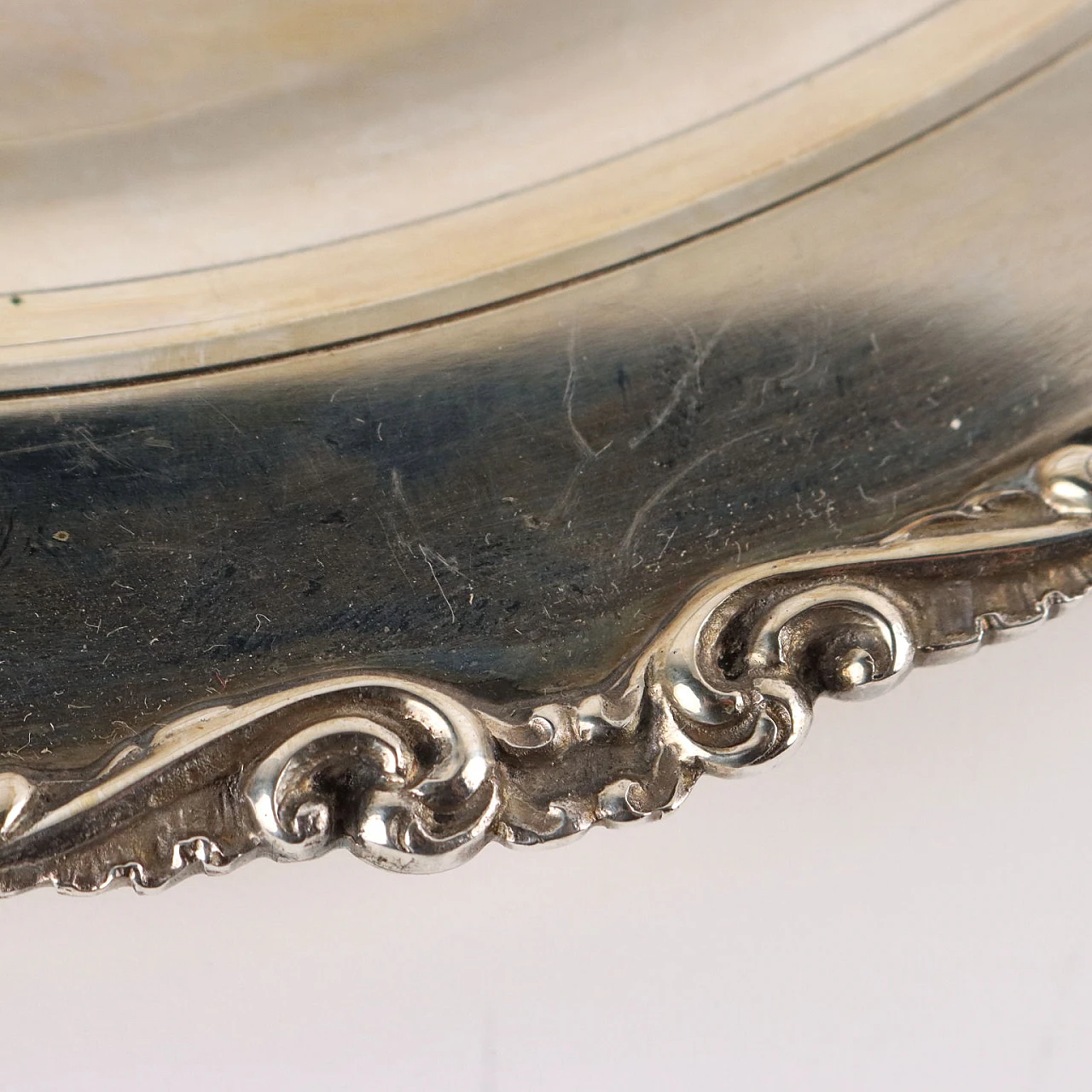 Piatto in argento con volute in rilievo sul bordo 4