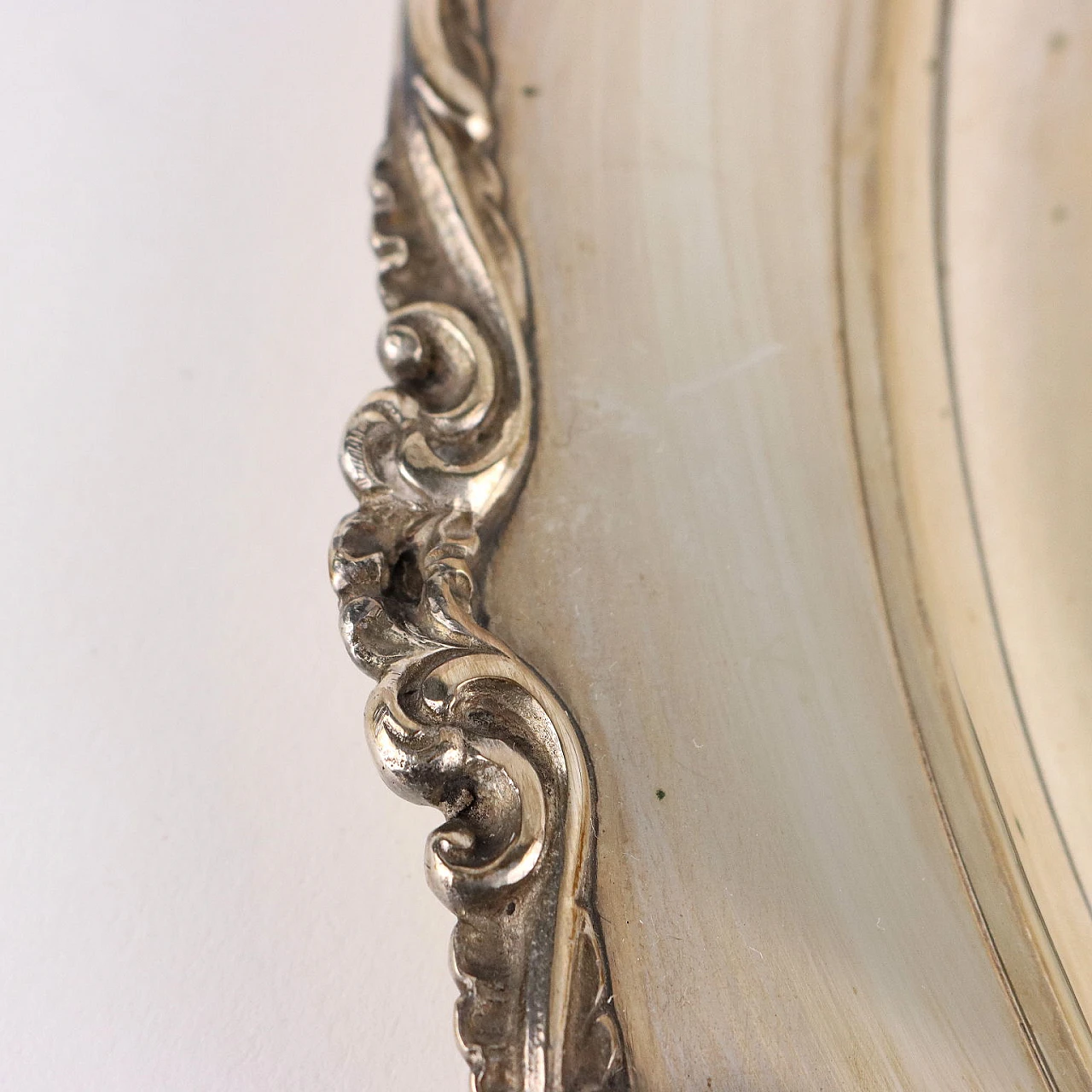 Piatto in argento con volute in rilievo sul bordo 5
