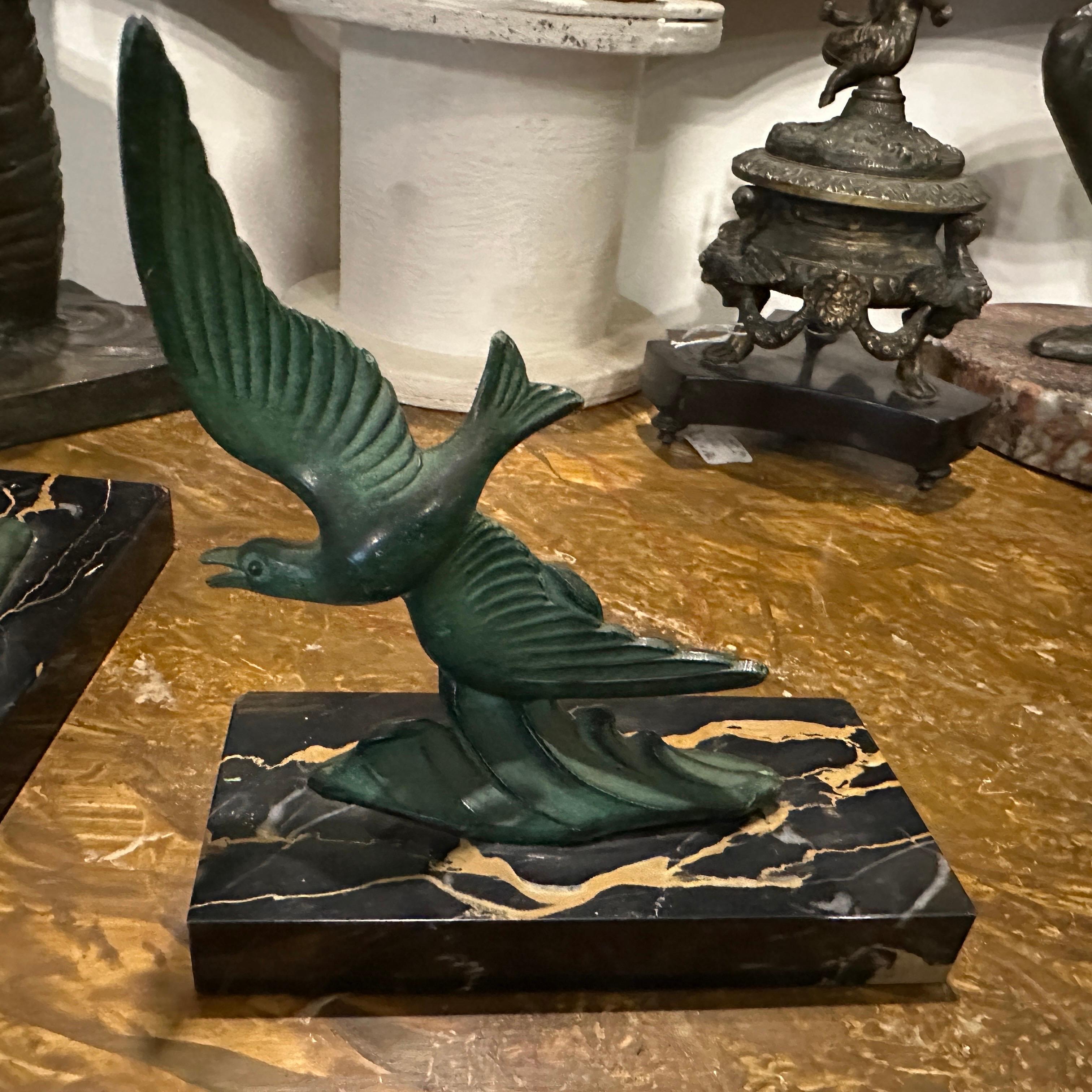 Coppia di reggilibri a forma di uccello in marmo e metallo, anni '30