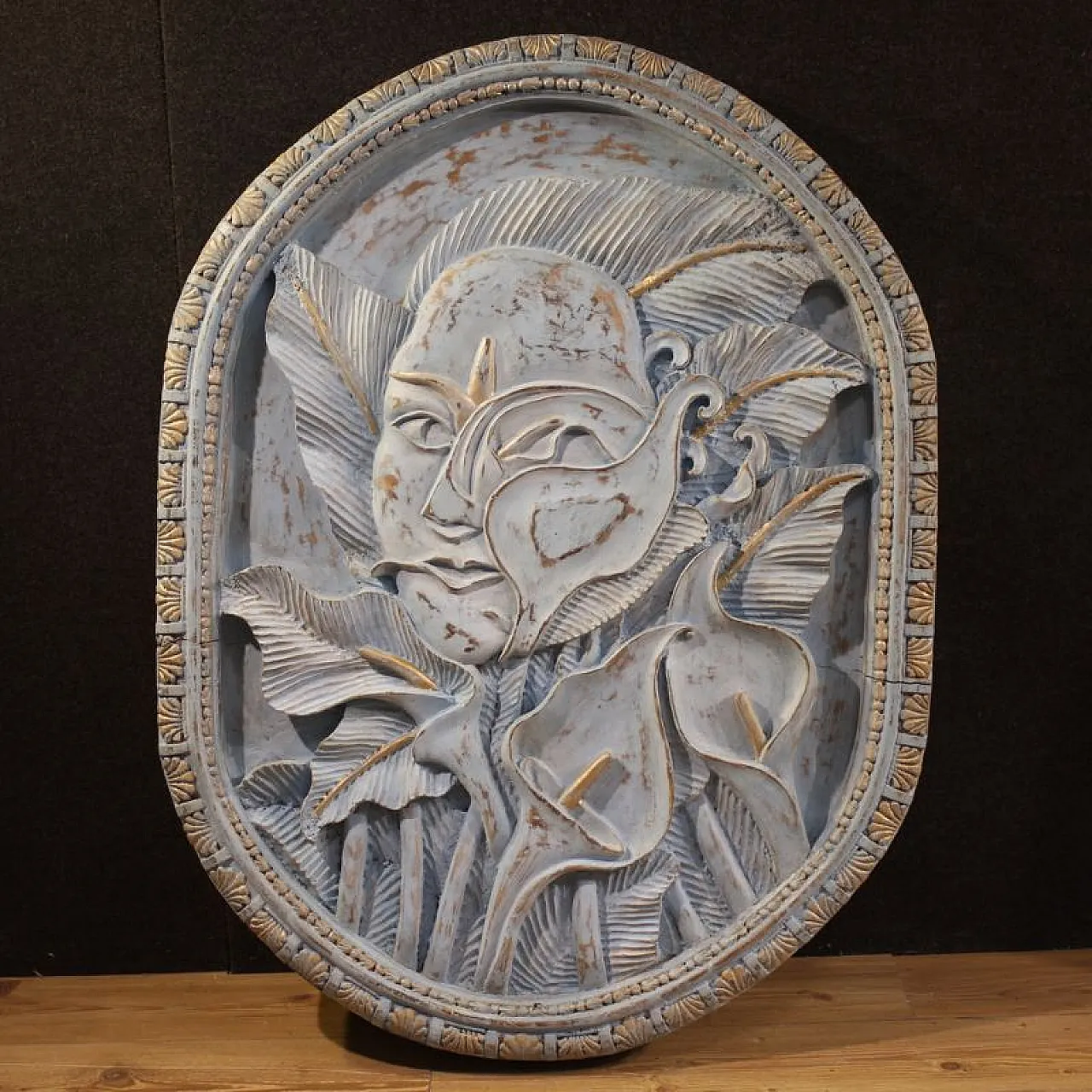 Bassorilievo in legno scolpito con volto stilizzato e fiori, '900 1