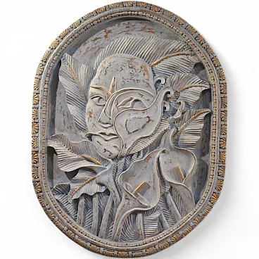 Bassorilievo in legno scolpito con volto stilizzato e fiori, '900